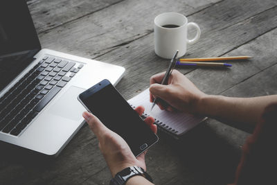 Midsection of man using laptop on table