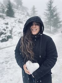 Portrait of young woman standing in snow