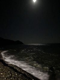 Scenic view of sea against clear sky at night