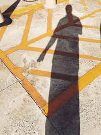 Low section of people on yellow shadow