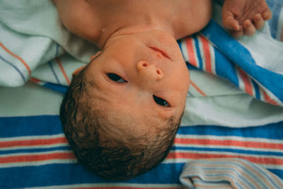 Close-up of newborn baby lying on bed