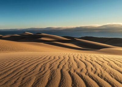 Scenic view of sand dune against sky