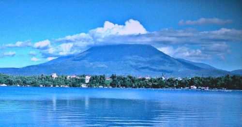 Scenic view of lake by mountains against sky