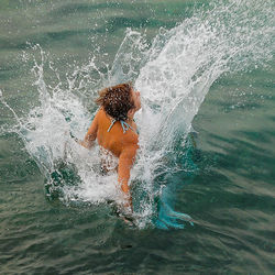 Boy splashing water in sea