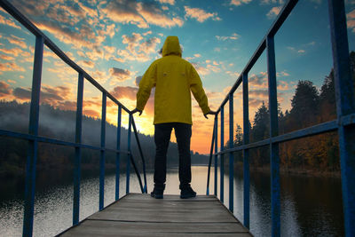 Rear view of man walking on footbridge