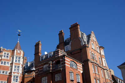 Low angle view of buildings against blue sky