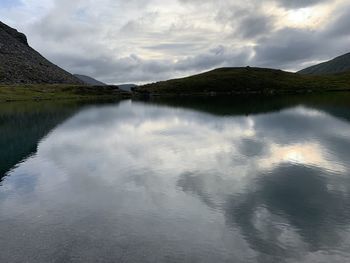 Scenic view of lake by mountains against sky