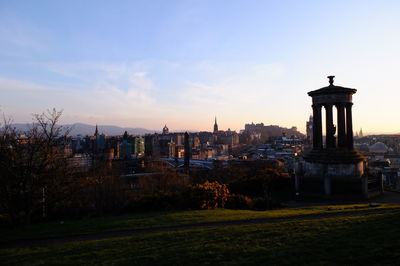 Silhouette dugald stewart monument at calton hill in city against sky during sunset