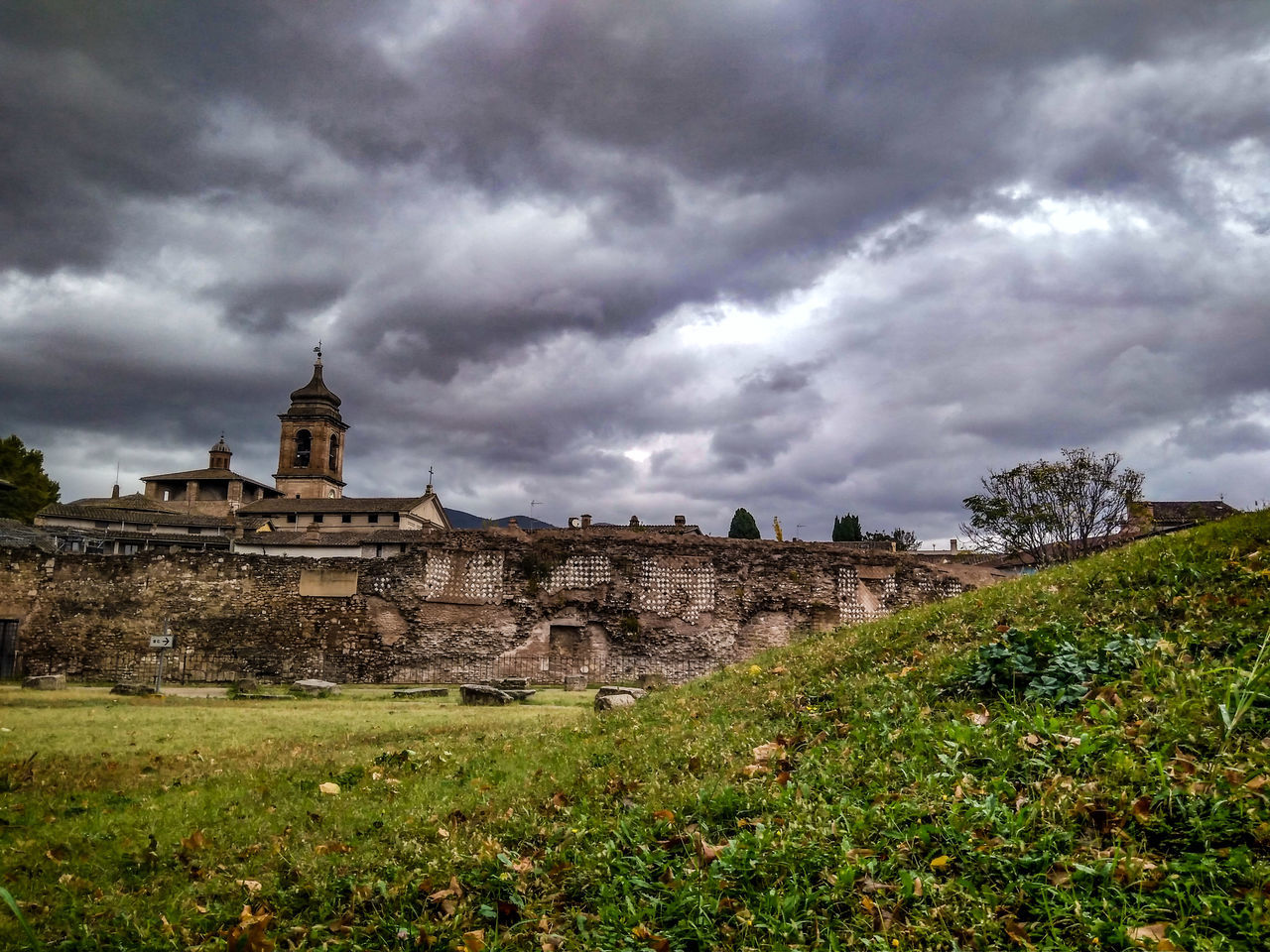 cloud - sky, sky, architecture, built structure, building exterior, nature, plant, overcast, building, history, grass, environment, the past, land, landscape, no people, storm, ancient, day, outdoors, ominous, ancient civilization