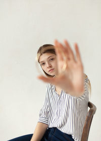 Portrait of woman sitting against wall