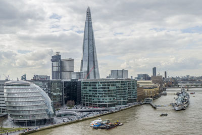 Buildings in city against cloudy sky