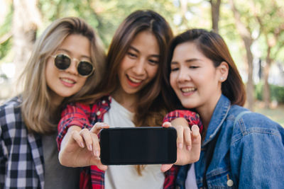 Portrait of a smiling young woman using smart phone