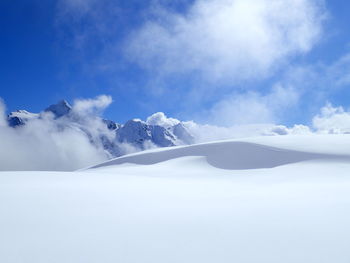 Low angle view of snowcapped mountains against sky