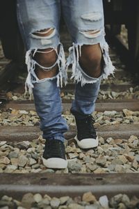 Low section of person walking on railroad tracks