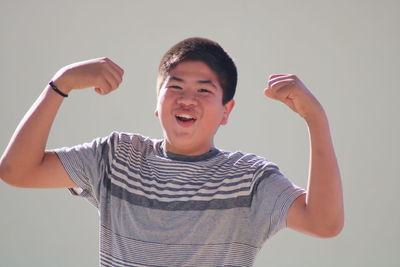 Portrait of happy boy standing against clear sky