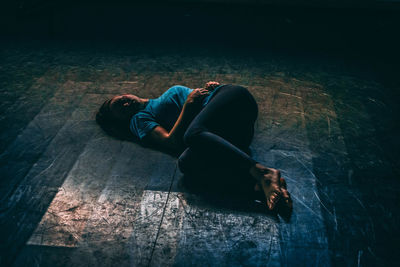 High angle view of young woman lying on floor at night