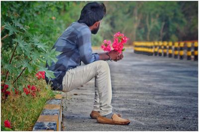 Rear view of man holding flower bouquet