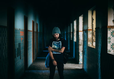 Full length portrait of man standing in corridor of building