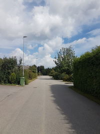 Empty road with trees in background