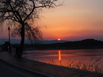 Scenic view of lake against orange sky