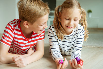 Girl with brother holding dices at home