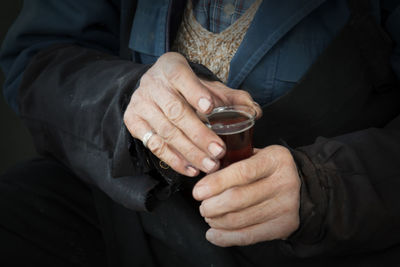 Midsection of man holding tea cup 