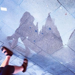 Reflection of woman and cologne cathedral on puddle