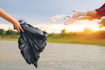 Midsection of woman holding umbrella against sky