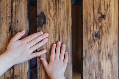 Cropped hands of woman and kid on wooden table