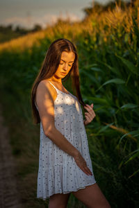 Young woman standing against plants