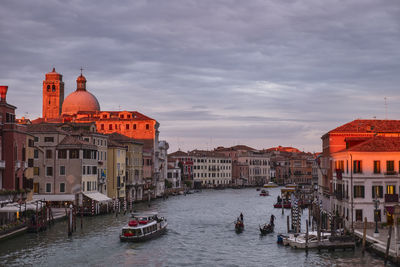 Boats in canal amidst buildings in city