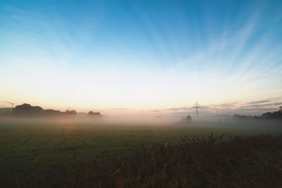 Scenic view of grassy field against cloudy sky