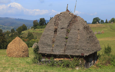 Hay bales on field against sky