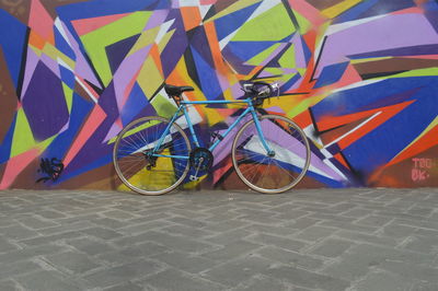 Close-up of multi colored umbrellas on tiled floor