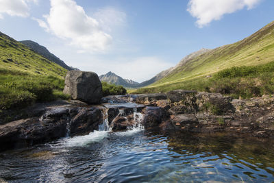 Stream and mountains against sky