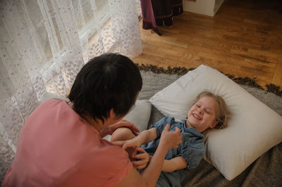 High angle view of mother and daughter on floor at home