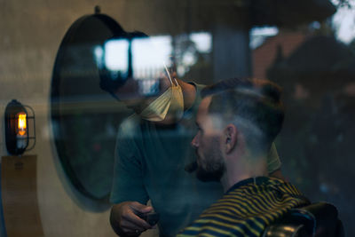 Portrait of young man looking through car windshield