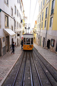 Train on railroad track in city against sky