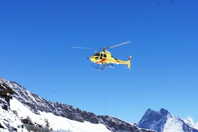 Low angle view of ski lift against blue sky