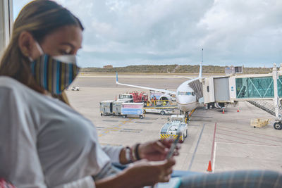 Young woman waiting to board the plane in the lounge the simon bolivar airport,  venezuela.