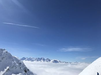 Scenic view of snowcapped mountains against blue sky