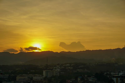 Silhouette buildings against sky during sunset