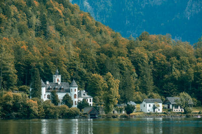 Scenic view of lake by trees and buildings