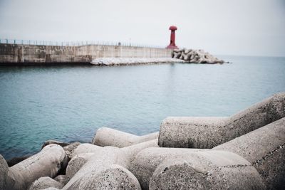 Stones at sea against sky