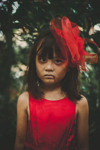 Portrait of a girl standing against red plants