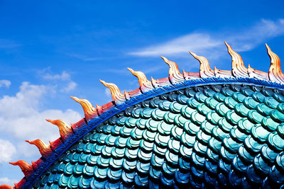 Low angle view of birds on roof against sky