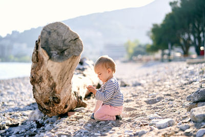 Full length of cute boy on rock