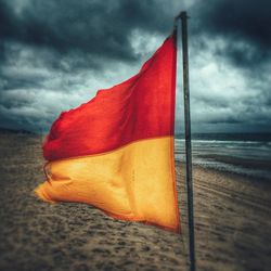Close-up of red flag on beach