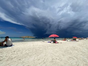 People at beach against sky