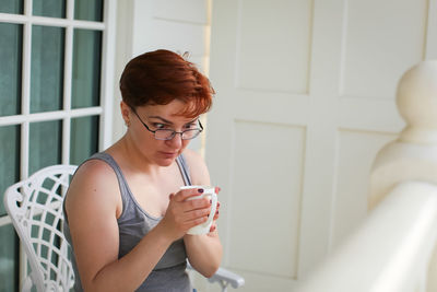 Young woman drinking glass at home